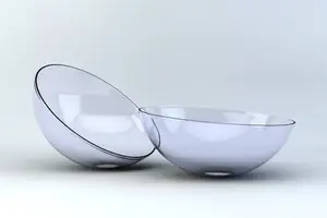 Two transparent glass bowls with a reflective surface placed on a white background