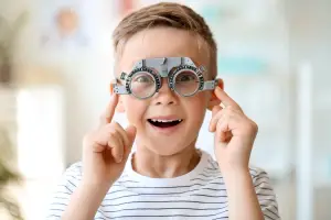 A boy wearing glasses and smiling for a photo