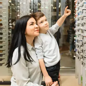 A woman and child looking at glasses in a store.