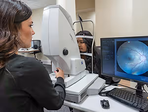 Woman checking the eye of another woman with an eye test machine