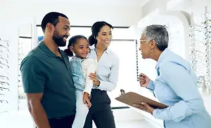Optometrist discussing eyewear options with a family in an optical store