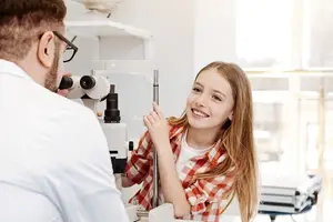 A young girl is having her eye examined by a doctor in a clinic.