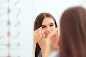 woman putting contact lens