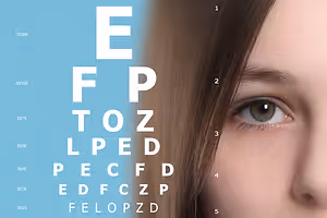 An eye chart for testing vision with a woman's face partially visible on the right side at North Coast Eye Care in Amherst, OH