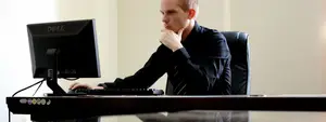 Man working on a computer in an office with a Dell monitor