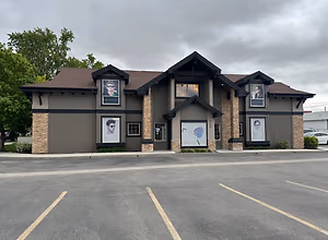 A building with a brown roof and three picture frames with a man wearing sunglasses