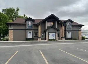 A building with a brown roof and three picture frames with a man wearing sunglasses