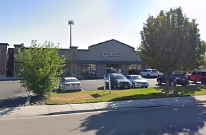 A photo of Eyecare Associates of Nampa building with parked cars in front and a clear sky.