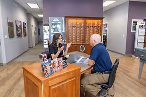 Two people sitting in front of a desk in an office