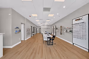 A Clear & Co. optical store with a large table in the center and shelves filled with eyewear and accessories on the walls.