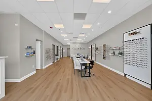 A Clear & Co. optical store with a large table in the center and shelves filled with eyewear and accessories on the walls.