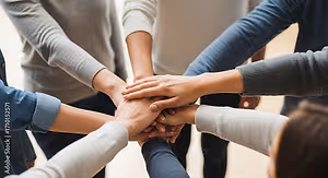 Teamwork, collaboration, unity and people gathering concept - group of diverse business people joining hands together in office.