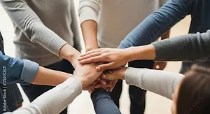 Teamwork, collaboration, unity and people gathering concept - group of diverse business people joining hands together in office.