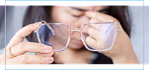 Asian woman holding glasses in her hands and rubbing her nose