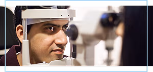 A man looking into an eye examination machine