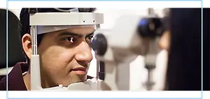 A man looking into an eye examination machine