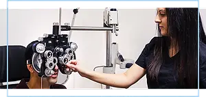 An optician is examining a patient's eyes with a machine