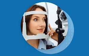 A woman is having her eyes checked by a doctor using an eye examination machine.