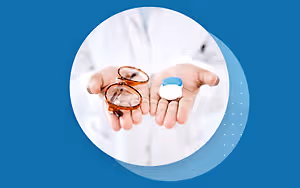 doctor holding a pair of glasses and a bottle of eye drops