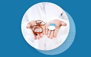 doctor holding a pair of glasses and a bottle of eye drops