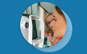 woman in optical shop looking at monitor with finger on eye