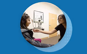 An eye doctor examining a child's eye in a clinic.
