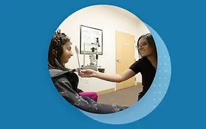 An eye doctor examining a child's eye in a clinic.