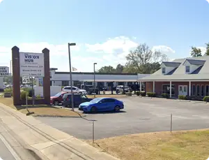 A photo of a road with cars parked in front of a building called The Vision Hub