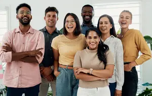 A group of people smiling and posing for a photo in an office setting