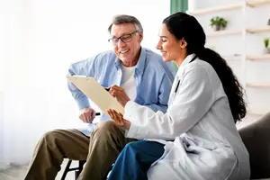Doctor sitting with a patient and smiling at them