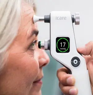 An older woman has her eye examined by an icare tonometer
