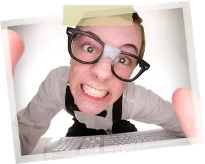 A person wearing glasses and a bow tie with a bandage on their nose is looking at a computer keyboard with a smile on their face.