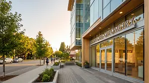 An outside view of VisionCare Optometry office building with people walking by.