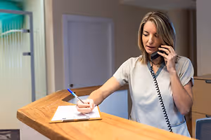 Midlothian eye doctor writing on clipboard at eye care center reception desk