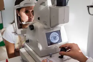 A woman is having an eye test with a doctor in a clinic.