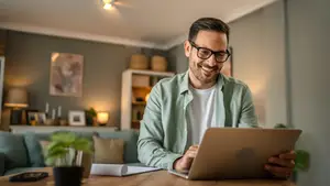 man sitting at table using laptop