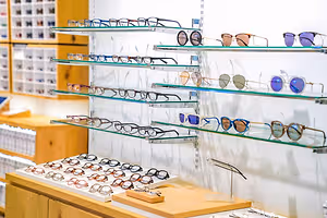 A store with glass shelves with eyeglasses on them