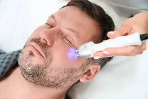 A person is having their face examined with a laser device