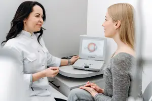 Woman in a white coat examining a patient in an ophthalmology clinic