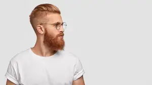 A man with a beard and glasses wearing a white t-shirt