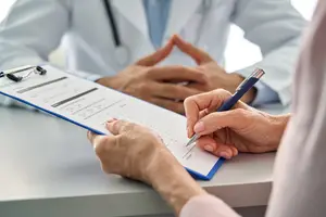 Doctor showing patient a form to sign