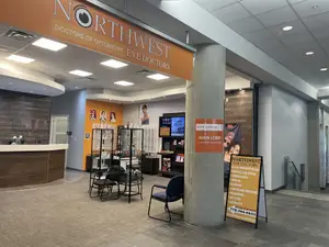 Northwest Doctors of Optometry Eye Doctors main lobby with chairs, desk, and a signboard.