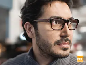 man wearing glasses and striped shirt looking to the side