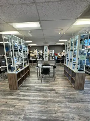 A modern jewelry store with glass display cases, wooden flooring, and ceiling lights.