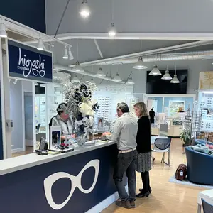 Three people in an eyewear store with a woman at the counter