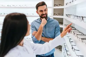 Man and woman looking at glasses inside of an opticians shop