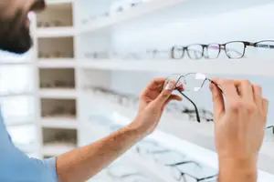 A man examining glasses in a store