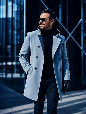 A man in a blue coat and black turtleneck is walking down a sidewalk.