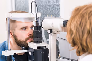 Man having his eyes checked by an optometrist in a clinic
