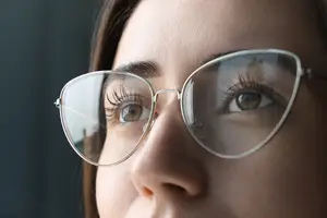 Close up of a woman's face with glasses on.